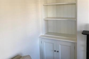 Display bookcases fitted into alcoves either side of the fire
